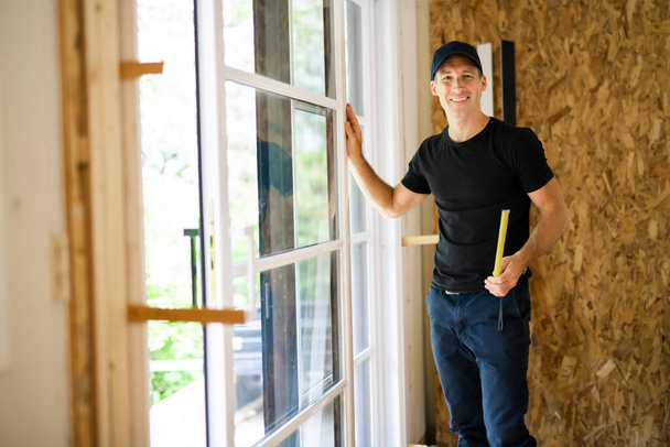 A handsome young man installing Double Sliding Patio Door in a new house construction site - Φωτογραφία, εικόνα