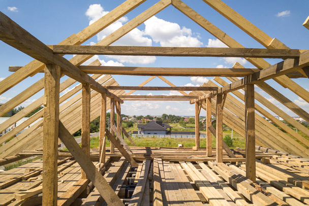 Widok z powietrza niedokończonego domu z drewnianą konstrukcją ramy dachu w budowie. - Zdjęcie, obraz