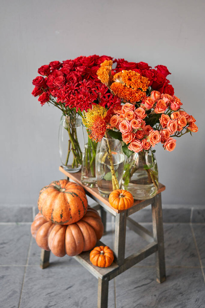 Set of pumpkins and orange and red flowers for Interior decorations. The work of the florist at a flower shop. Fresh cut flower. Autumn mood. - Photo, Image