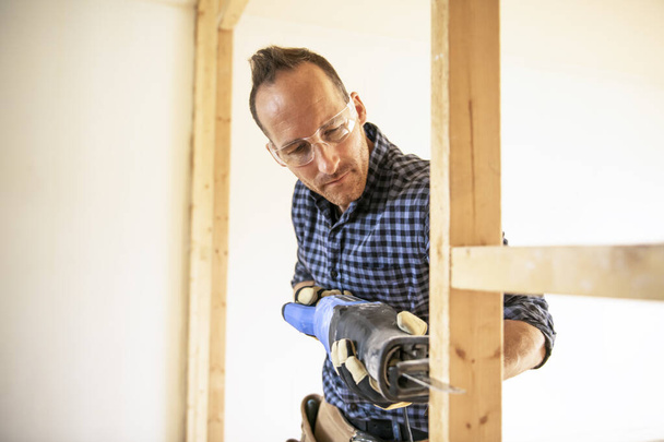 A man worker in the carpenter workroom renovation - Φωτογραφία, εικόνα
