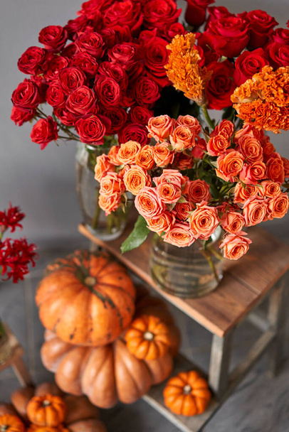 Sonbahar havası. İç dekorasyon için balkabağı, turuncu ve kırmızı çiçekler. Çiçekçi dükkanındaki çiçekçinin işi. Taze kesilmiş çiçek.. - Fotoğraf, Görsel