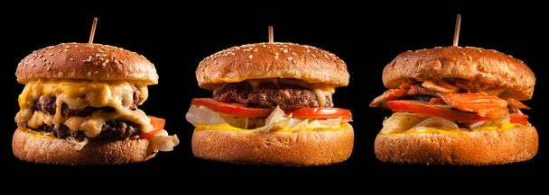 Hambúrgueres isolados sobre fundo preto. Hambúrguer, cheeseburger e hambúrguer de peixe para o menu do restaurante. - Foto, Imagem