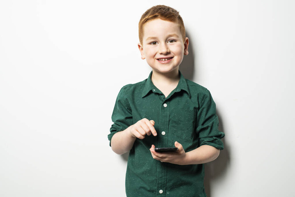 Conceptual photo of a boy texting on his cell phone in a studio - Foto, immagini
