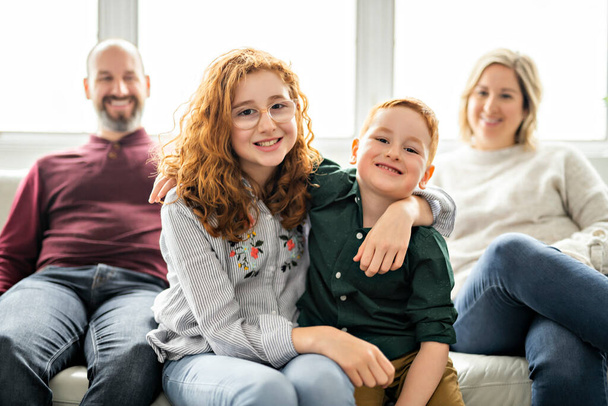 A Beautiful happy family having fun on sofa at home - Fotografie, Obrázek