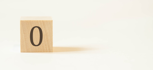 Число "ноль" на деревянном кубе с белым фоном. - Фото, изображение