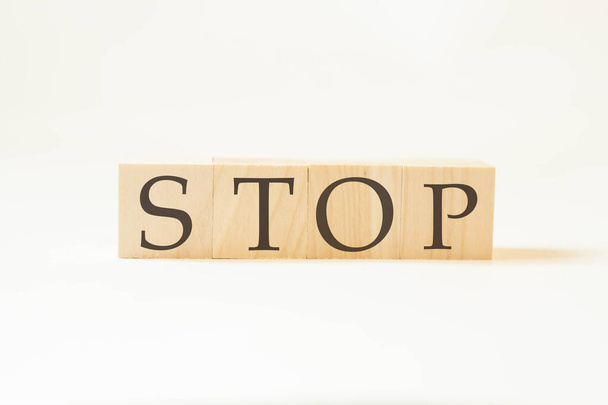 Stop het woord op houten kubussen met witte achtergrond. Grote letters. - Foto, afbeelding