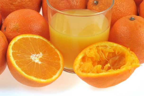 Bicchiere di succo d'arancia spremuto e arance fresche da vicino  - Foto, immagini