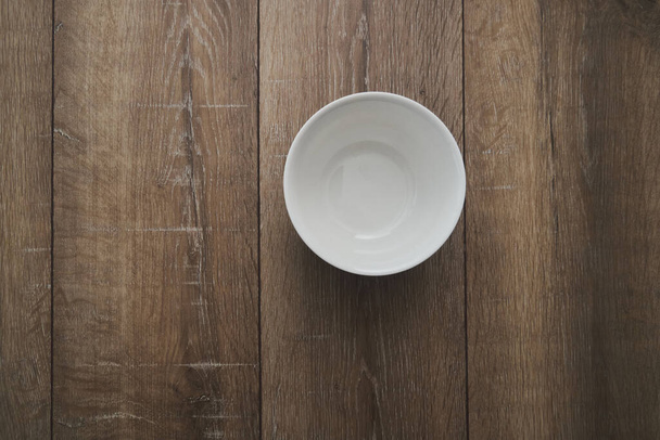top view of an empty white Bowl on a wooden background  - Foto, afbeelding