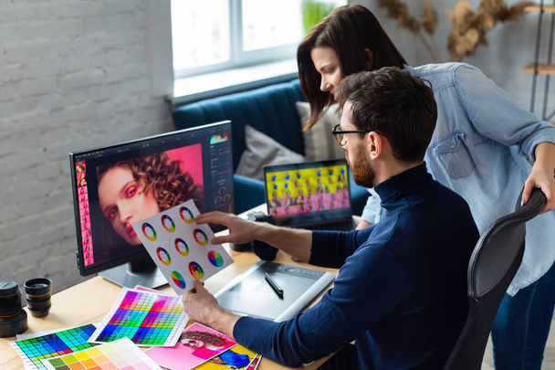 Photographer and graphic designer working in office with laptop, monitor, graphic drawing tablet and color palette. Creating team discussing ideas in advertising agency. Retouching images. Teamwork - Foto, Imagen