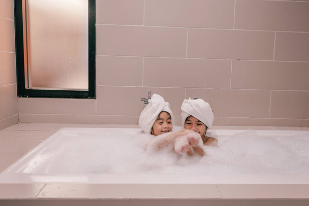 two daughters with bubbles in bathtub - Fotoğraf, Görsel