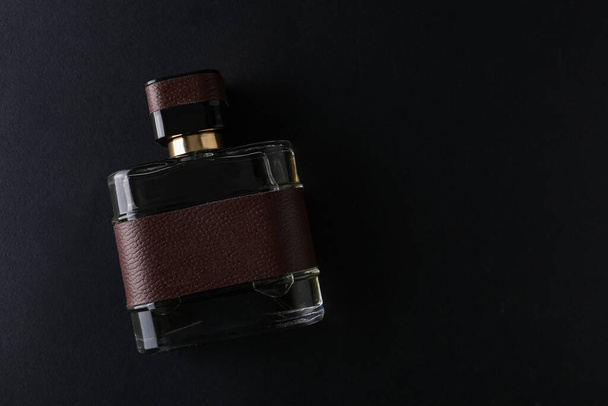 Burla de fragancia negra botella de perfume maqueta sobre fondo vacío oscuro. Vista superior. Horizontal - Foto, Imagen