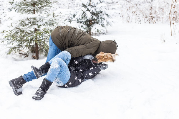 Estilo de vida, temporada y concepto de ocio - Pareja divertida jugando bola de nieve en el parque de invierno - Foto, Imagen