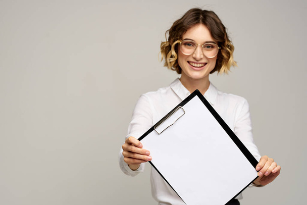Business woman in a light shirt and a folder with documents in hands cropped view of work - Photo, Image