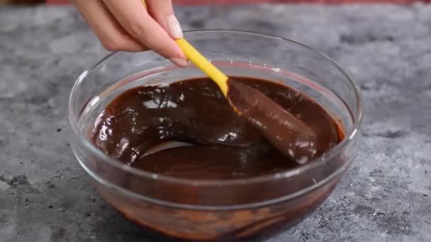 Kobieta mieszając pyszny sos czekoladowy w misce. - Materiał filmowy, wideo