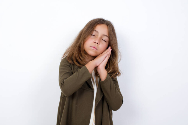 Young beautiful Caucasian little girl with sleep gesture on white background  - Foto, immagini