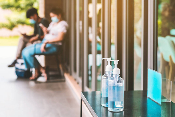 手掃除用ブルーアルコールジェルボトルは、コロナウイルス(Covid-19)の拡散を防ぐために、カフェに顧客のための入り口サービスを配置します。医療の概念。新しい普通の生活様式. - 写真・画像