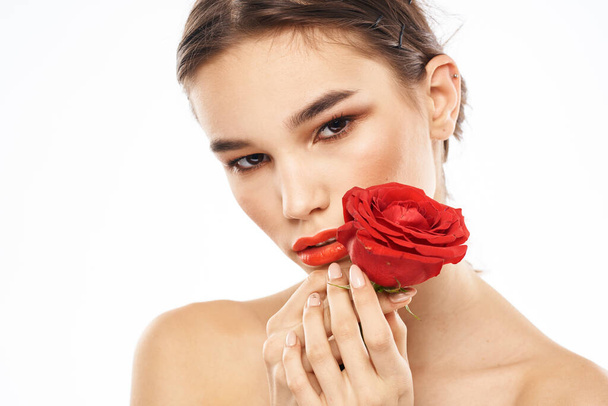 Charmante Brünette mit Make-up im Gesicht und einer roten Rose in der Hand - Foto, Bild