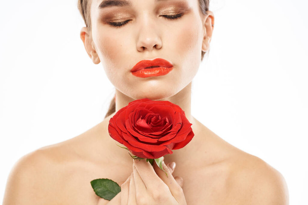Beautiful woman with red rose near face makeup naked shoulders portrait - Valokuva, kuva