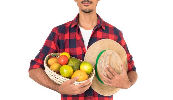 Средняя часть фермера держит корзину фруктов (апельсин, манга, авокадо и хаки) на белом фоне - Фото, изображение