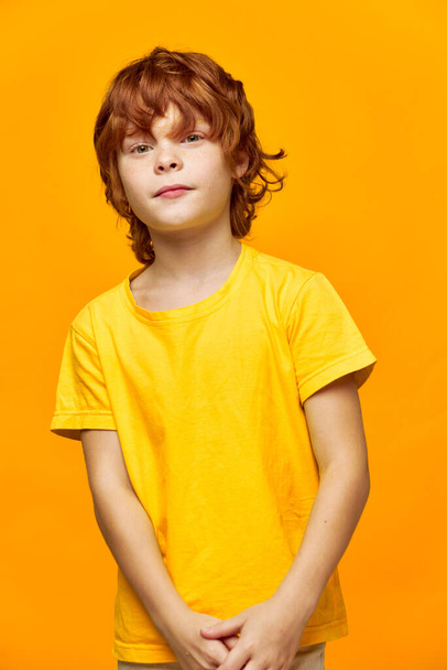 Το παιδί με τα κόκκινα μαλλιά σε ένα απομονωμένο φόντο - Φωτογραφία, εικόνα