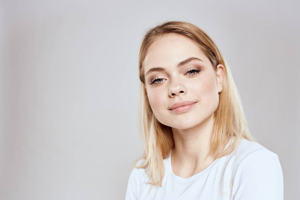 Cheerful blonde woman in white t-shirt cropped view light background - Fotografie, Obrázek