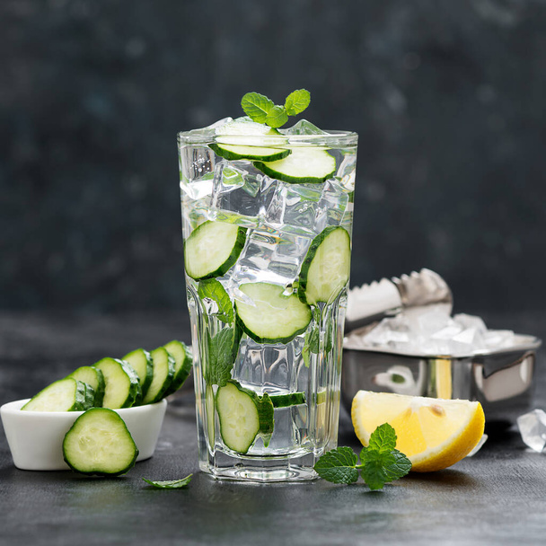 Healthy fresh cucumber lemonade with lemon and ice cubes. - Fotó, kép