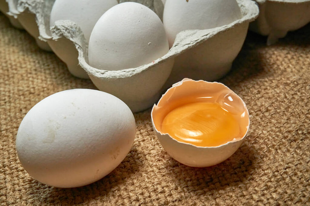 Νωπά ωμά αυγά κοτόπουλου σε χαρτόκουτο σε λινάτσα - Φωτογραφία, εικόνα