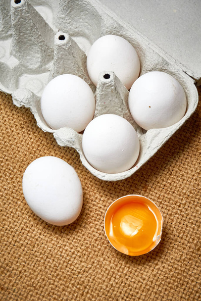 Ovos de galinha crus frescos em uma caixa de papelão em um fundo de serapilheira - Foto, Imagem