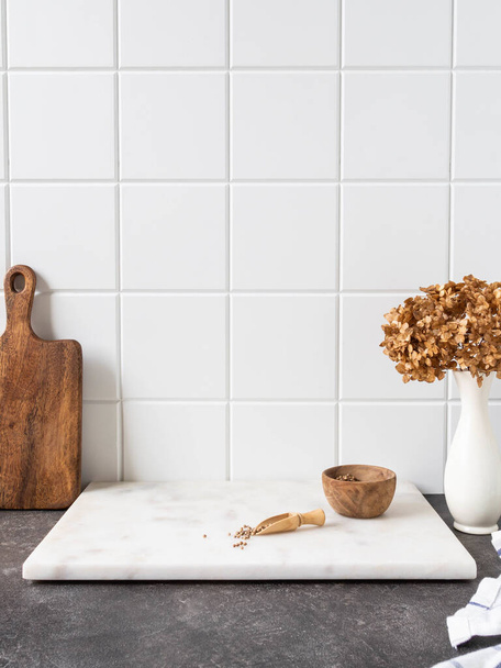 Fundo de cozinha branca elegante com utensílios de cozinha marrom e decoração em pé na bancada cinza textupe, espaço de cópia, vista frontal - Foto, Imagem