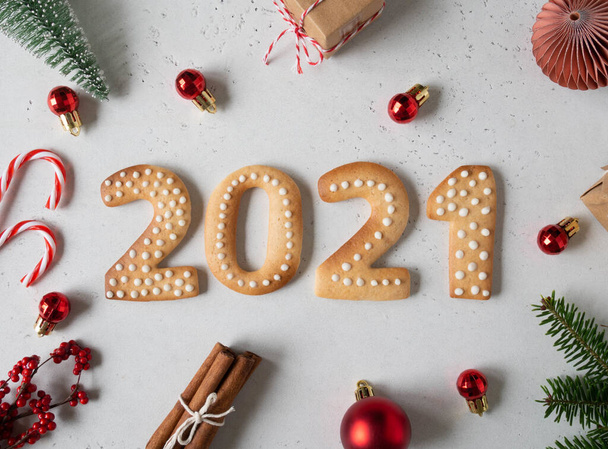 Gingerbread cookies in the form of numbers, gingerbread New Year 2021 and festive decor on grey background . Top view. Flat lay - Photo, Image