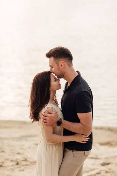 Romantikus pár csókolózik a szabadban. elegáns és elegáns nő és férfi szerelmes sétálnak a tó mentén. Boldog pillanatokat együtt. Szerelmi történet. - Fotó, kép