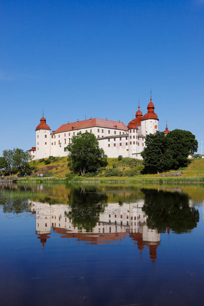 The medieval Lacko castle located in the Swedish province of Vastergotlande is reflected in lake Vanern. - Photo, Image