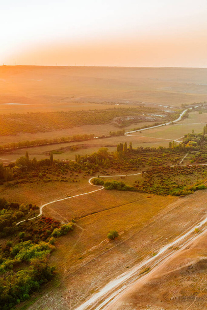 Vista da altura da rocha branca e vale verde em luzes laranja por do sol. Céu azul, uma pequena aldeia no fundo. República da Crimeia - Foto, Imagem