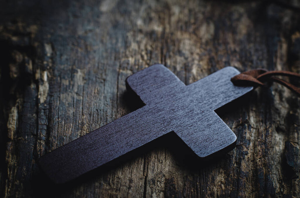 Groot houten christelijk kruis op een oude houten achtergrond. Religieus concept - Foto, afbeelding