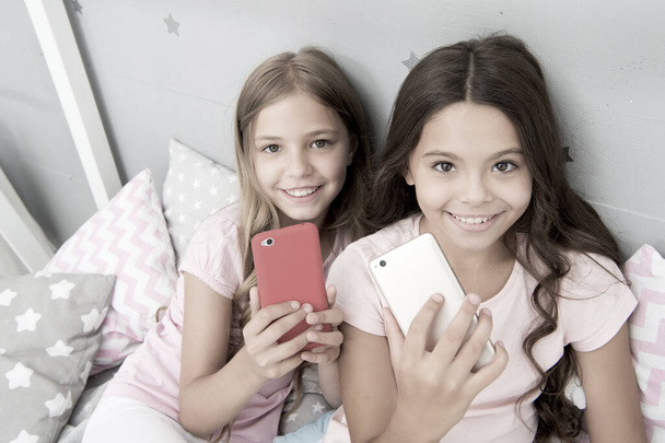 Explore social network. Kids taking selfie. Smartphone application concept. Online entertainment. Girlish leisure pajama party. Girls smartphone little bloggers. Smartphone for entertainment - Foto, imagen
