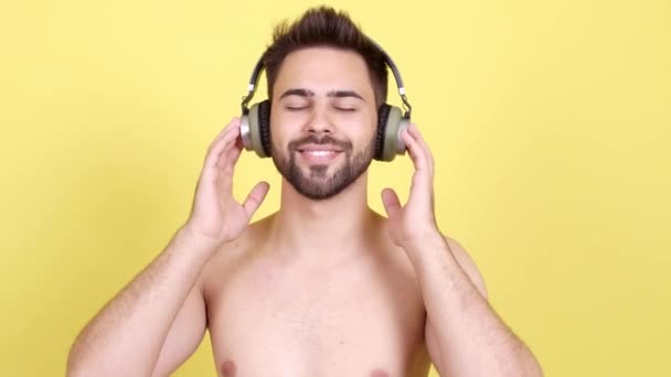 Knappe jongeman luisteren naar muziek tegen kleur achtergrond - Video