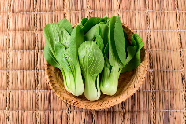 Fresh Bok Choy or Pak Choi(Chinese cabbage) in bamboo basket, Organic vegetables, Top view - Фото, изображение