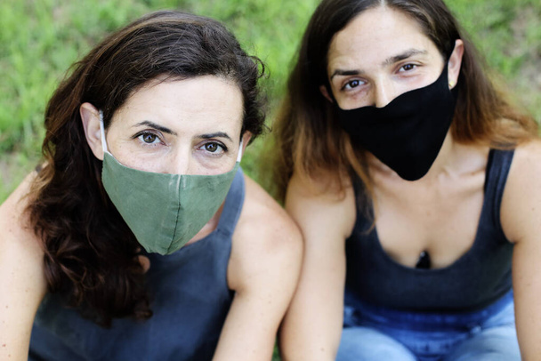 Πορτρέτο δύο ελκυστικών ώριμων γυναικών με μάσκα. Στυλ Coronavirus - Φωτογραφία, εικόνα