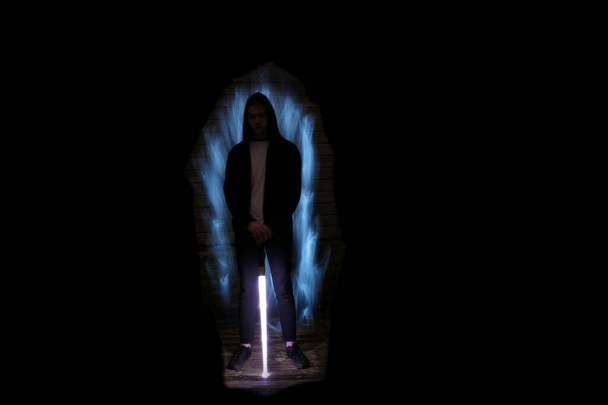 Silhouette d'un homme avec un sabre léger. Scène Lightpainting. Garçon avec fibre optique légère et LED en arrière-plan. - Photo, image