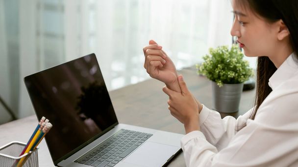 Young women suffer from wrist pain from typing in computers for a long time, May cause office syndrome. - Foto, imagen