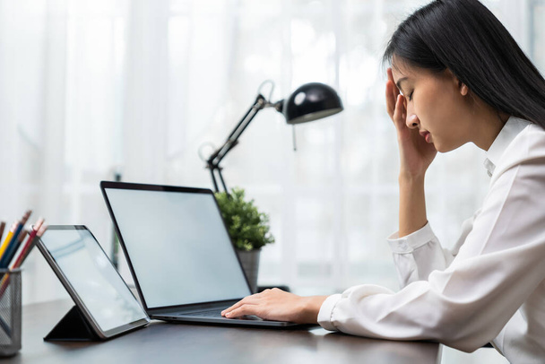 Azji biznes kobieta cierpi na ból głowy od pracy z komputerami przez długi czas. - Zdjęcie, obraz
