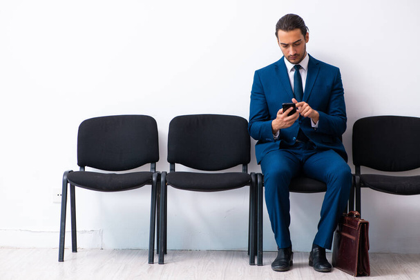 Egy fiatal üzletember vár egy interjúra a hallban. - Fotó, kép