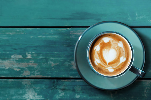 Mavi Tahta Masa 'da sıcak kahve fincanı. Üst Manzara. Kalp Şeklinde Latte Sanatı - Fotoğraf, Görsel