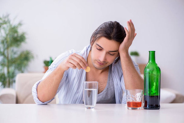 Fiatal férfi alkoholista whiskey-t iszik otthon - Fotó, kép
