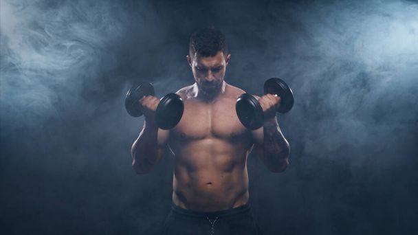 Fit and sporty bodybuilder over black background. Caucasian sportsman in studio. Sport and fitness concepts. - Fotografie, Obrázek
