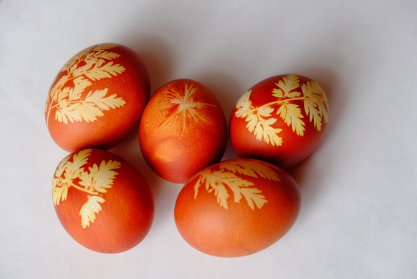 Painted Easter eggs on a white background. Floral pattern on a red eggshell. Festive food. - Fotoğraf, Görsel
