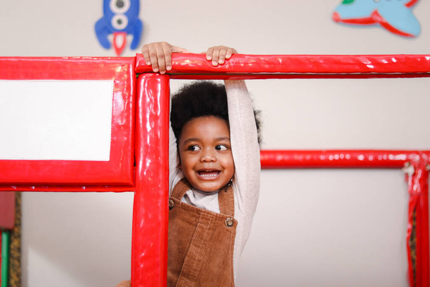 Criança alegre feliz, menino afro-americano com cabelo encaracolado, se divertindo no playground, criança pequena brincando com o amigo. - Foto, Imagem