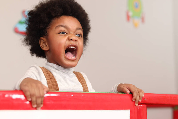 Afrikai amerikai fiú göndör haj kiabál, miközben játszik a játszótéren, gyerek szórakozás játszótéren.  - Fotó, kép