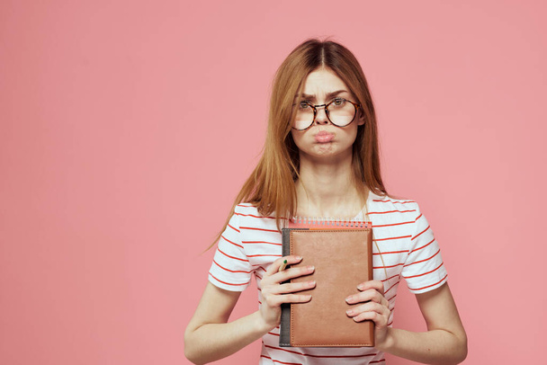 Młoda studentka z książkami o różowych okularach tła na twarzy instytucji edukacyjnej widok przycięty - Zdjęcie, obraz