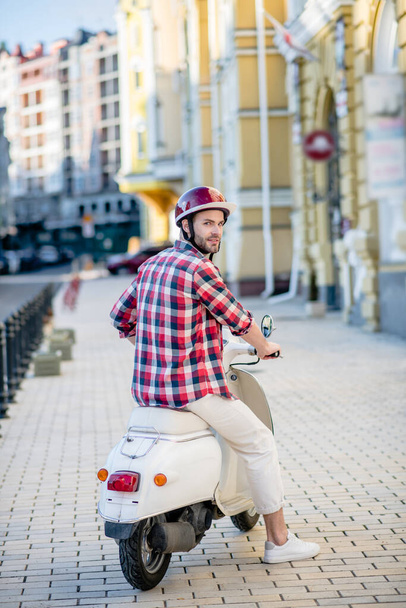 Man taking off on his white scooter - Photo, Image